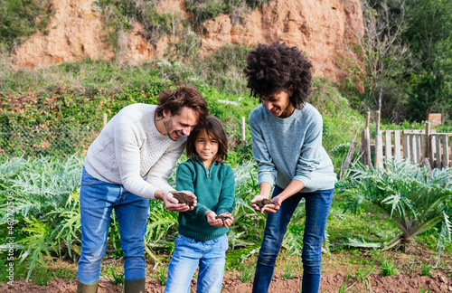 hapy family holding soil in their cupped hands photo