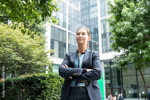 Businesswoman with arms crossed standing at office park