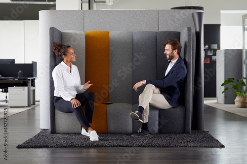 Colleagues keeping distance while talking together in office
