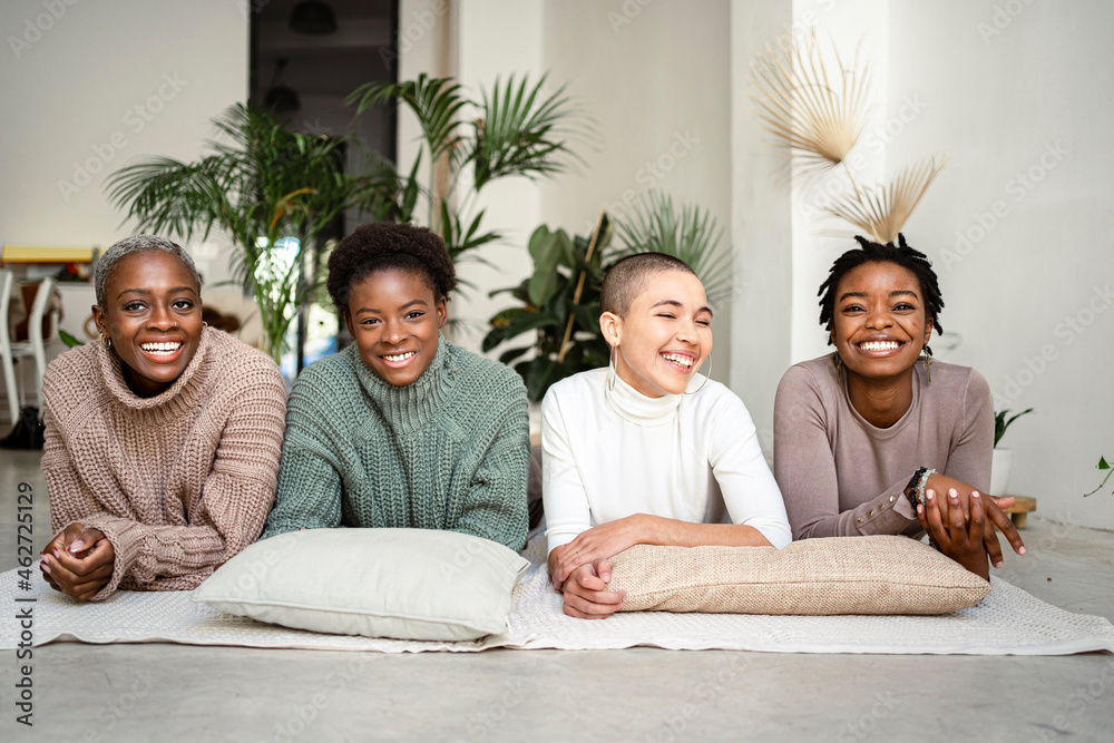 © Rafa Cort√©s/Westend61 - Smiling female friends lying on front in living room