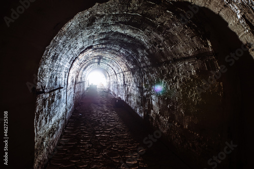 Dark underground tunnel. Light at the end of tunnel