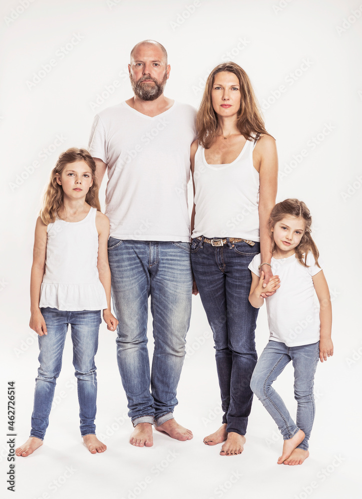 Portrait of family with two daughters standing in front of white background Portrait of family with two daughters standing in front of white background