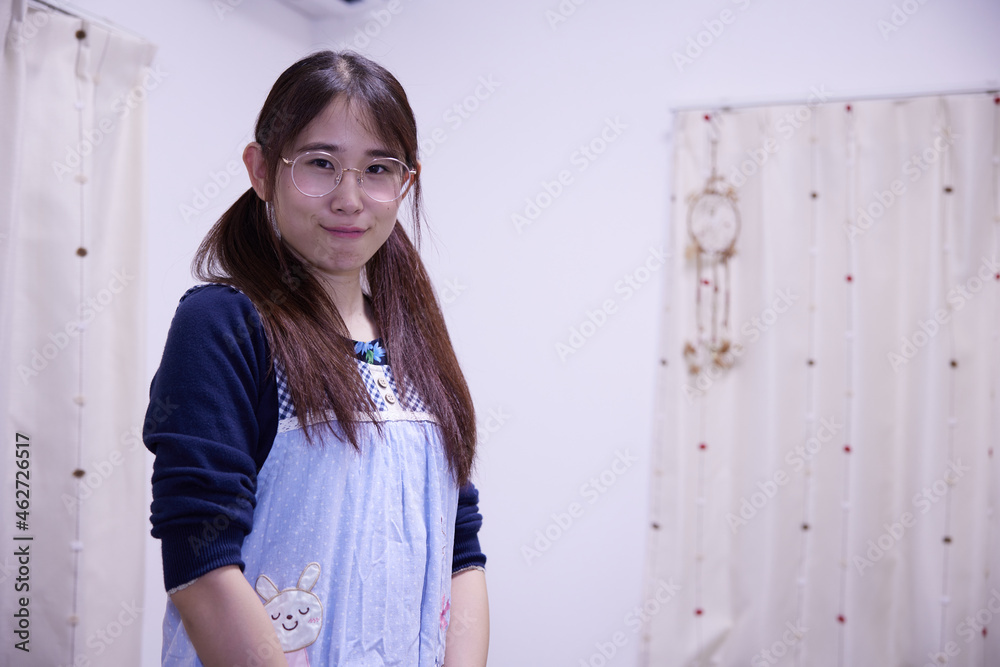 眼鏡をかけ、エプロンを付けたアジア人女性 眼鏡をかけ、エプロンを付けたアジア人女性