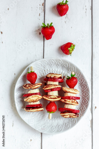 Plate of mini pancakes with strawberries and bananas