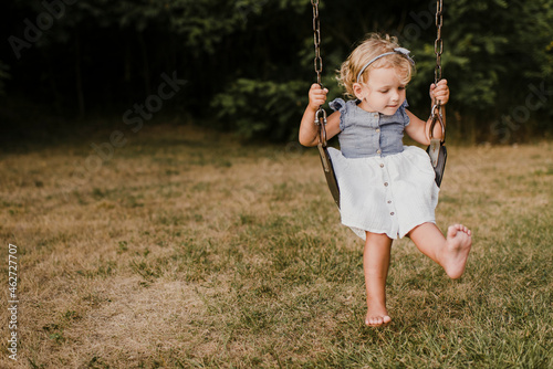 Cute little girl on  a swing photo