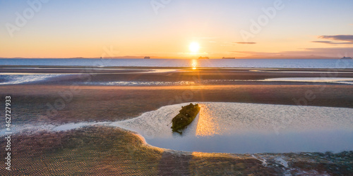 UK, Scotland, Wreck of X-Craft submarine lying on shore of Aberlady Bay at sunset