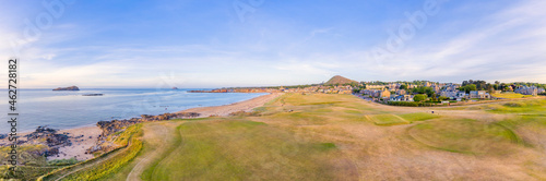 UK, Scotland, North Berwick, Aerial panorama of golf course in front of coastal town in summer photo
