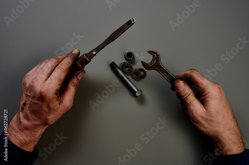 Top view of hand with tools in front of grey background photo