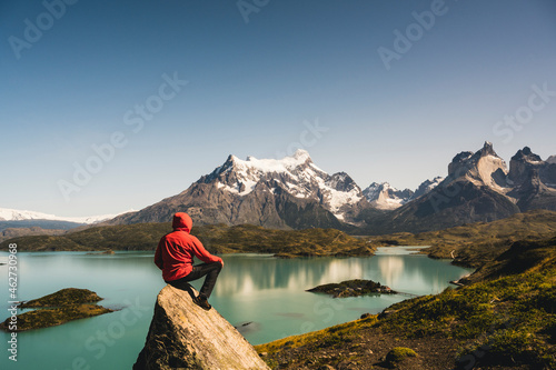 Man in hooded jacket looking at view of Lake Pehoe in Torres Del Paine National Park, Chile Patagonia, South America photo