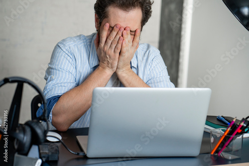 Exhausted man with laptop at home