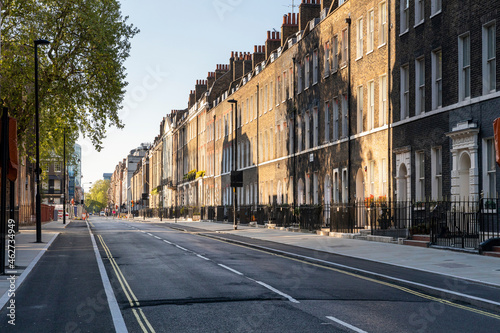 UK, London, Shadows on brick buidings in empty street photo
