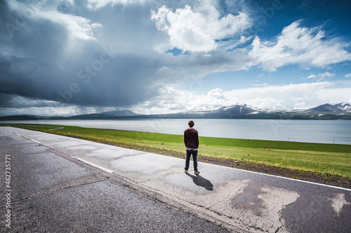 Georgia  Samtskhe-Javakheti  Poka  Young man standing at roadside admiring alpine lake
