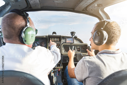 Pilot and copilot navigating sports plane, rear view