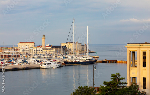 Italy, Friuli Venezia Giulia, Trieste, Boats moored in San Giusto Sea Center marina withÔøΩLa Lanterna lighthouse in background photo