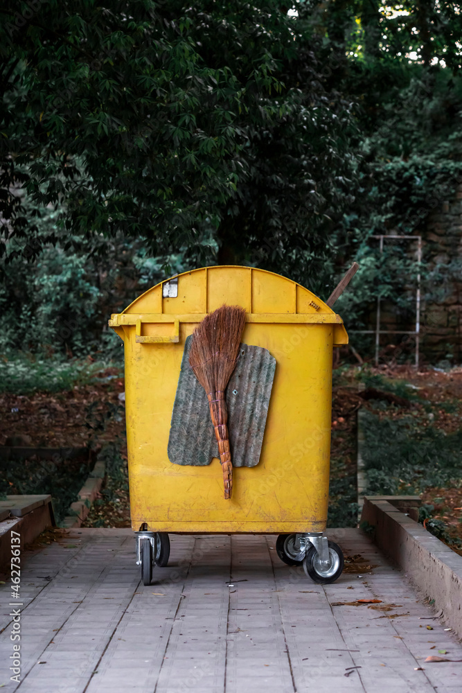 Georgia, Imereti, Kutaisi, Yellow garbage bin with broom Georgia, Imereti, Kutaisi, Yellow garbage bin with broom