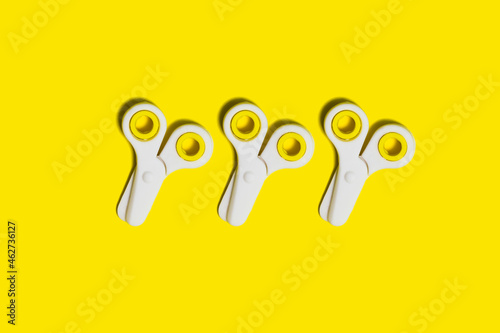 Studio shot of three pairs of school scissors against yellow background photo