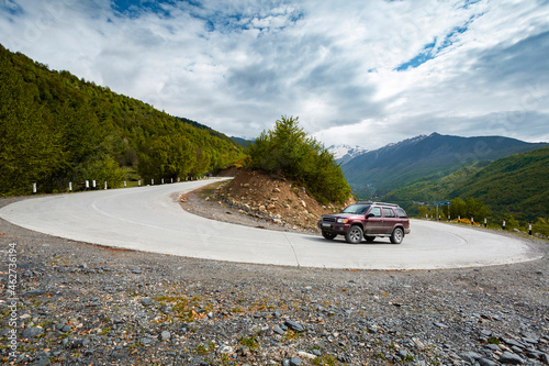 Georgia, 4x4 car passing hairpin turn on winding mountain road