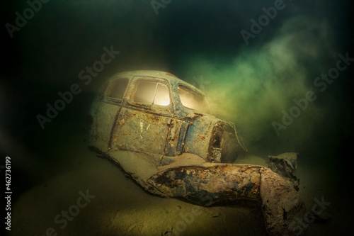 Underwater view of rusty car wreck deteriorating at bottom of Lake Atter photo