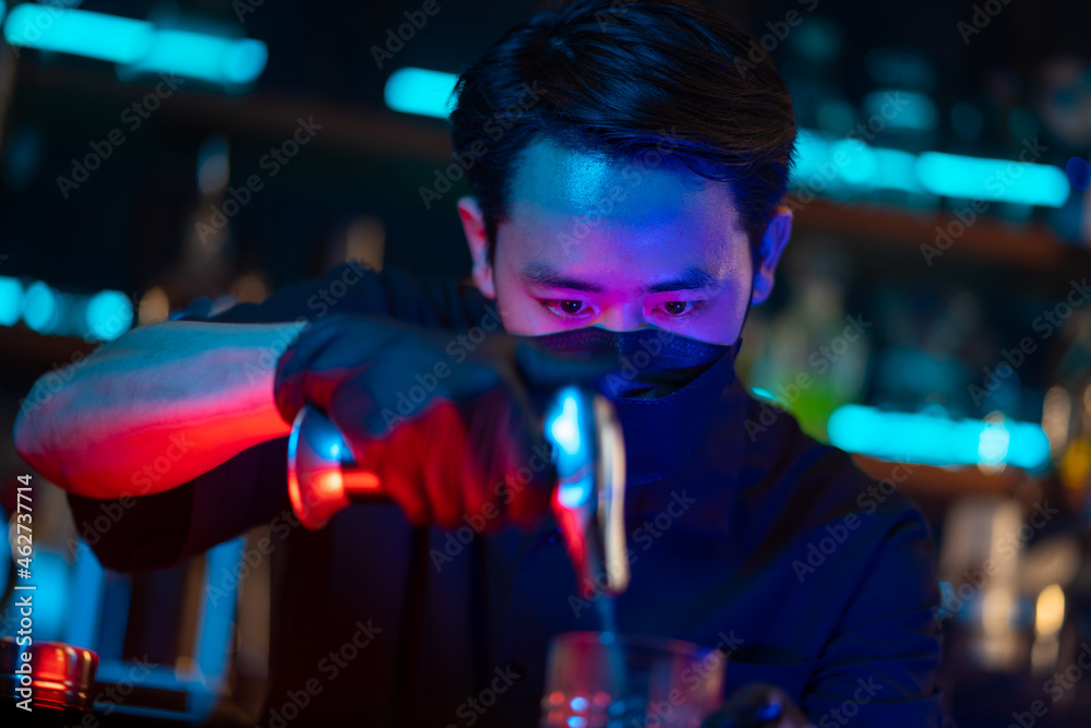Asian man bartender making special cocktail explode alcoholic drink with cinnamon powder on bar counter serving to customer at nightclub with neon night lights. Small business food and drink concept Asian man bartender making special cocktail explode alcoholic drink with cinnamon powder on bar counter serving to customer at nightclub with neon night lights. Small business food and drink concept