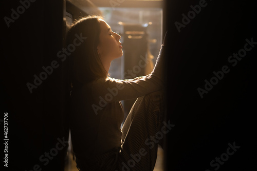 Loneliness Asian woman sitting on the floor with hugging herself. Beautiful female feeling depressed living alone in the dark and think of life problems. Mental health and social issue concept.