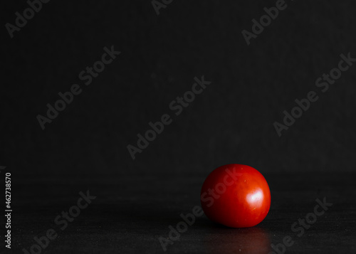 single tomato on black