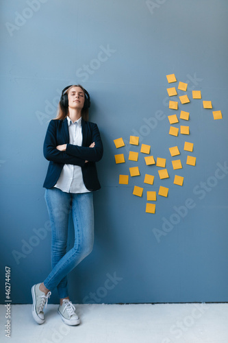 Young businesswoman wearing headphones, listeining music photo