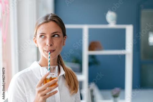 Young woman drinking tea with a straw photo