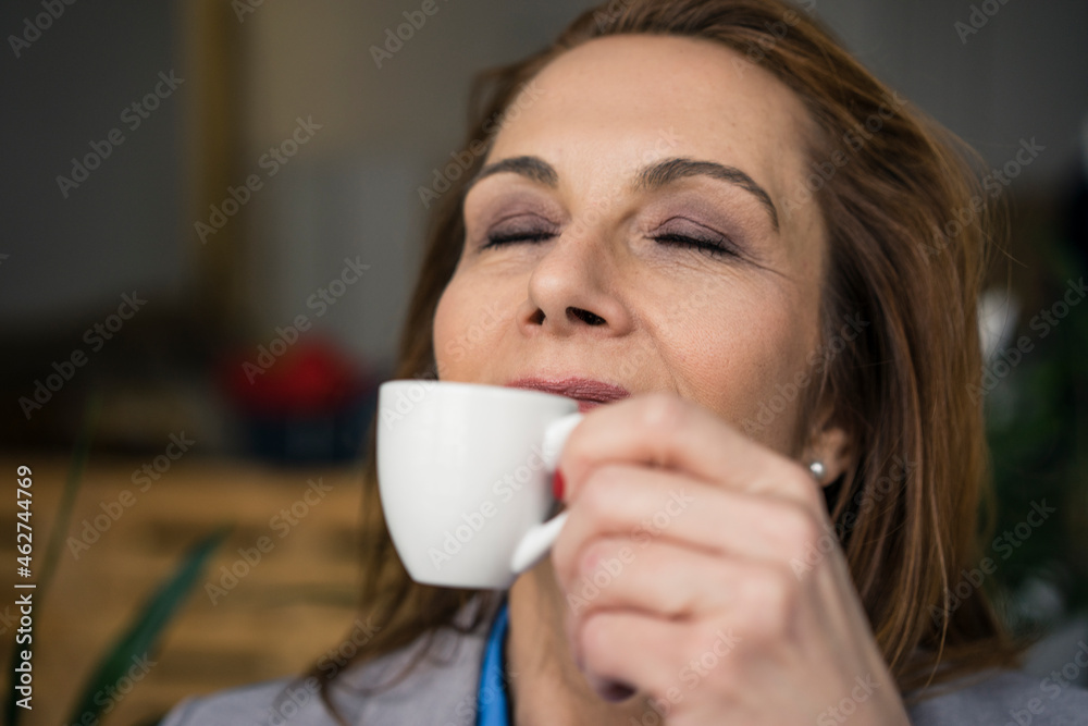 Redheaded businesswoman taking a break, drinking coffee Redheaded businesswoman taking a break, drinking coffee