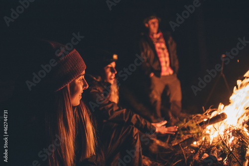 Friends warming up at the campfire photo