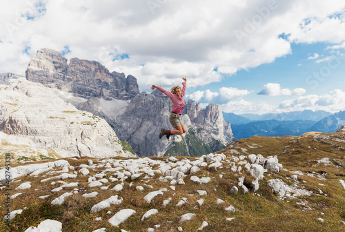 Female hiker jumping, Tre Cime di Lavaredo Area, Nature Park Tre Cime, Unesco World Heritage Natural Site, Sexten Dolomites, Italy photo