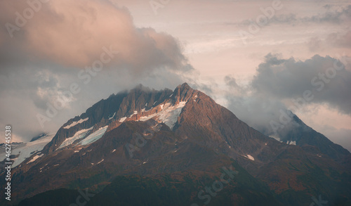 View of mountain peak surrounded by clouds in Alaska, USA.