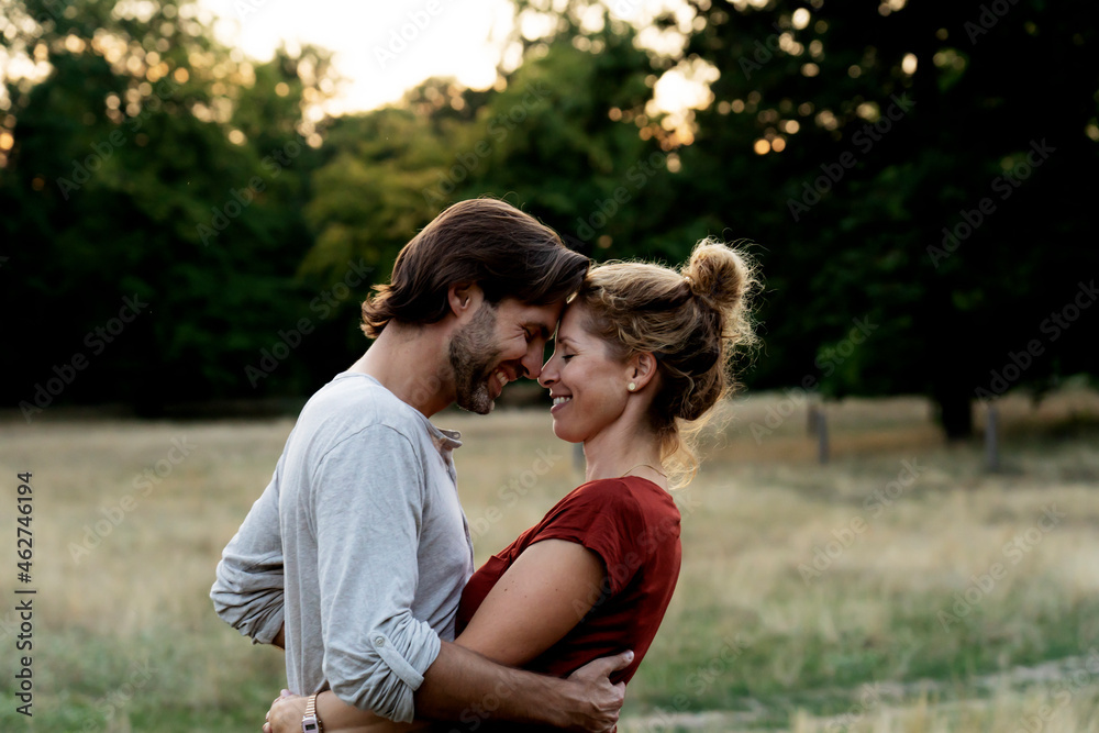 Happy couple in nature, standing face to face, caressing each other Happy couple in nature, standing face to face, caressing each other