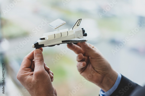 Close-up of bussinessman holding space shuttle model photo