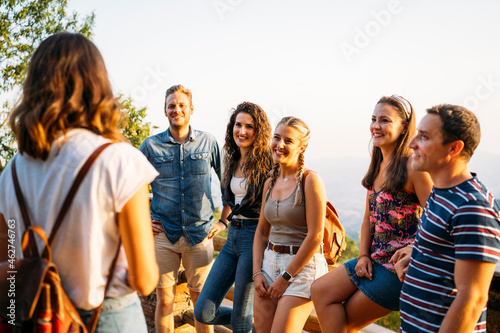 Group of friends looking at woman leading a tour photo