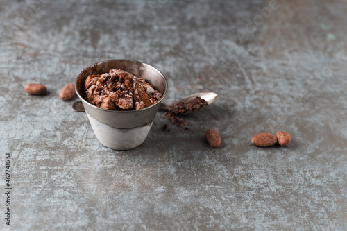 Cup of chocolate icecream sprinkled with cacao and cacao nibs photo