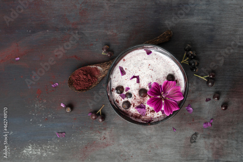 Bowl of natural yoghurt with Aronia powder and hollyhock flower photo