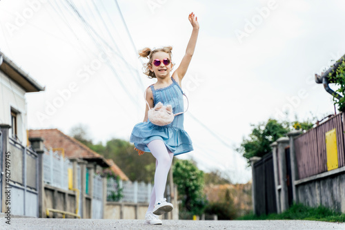 Happy little girl dancing on the street