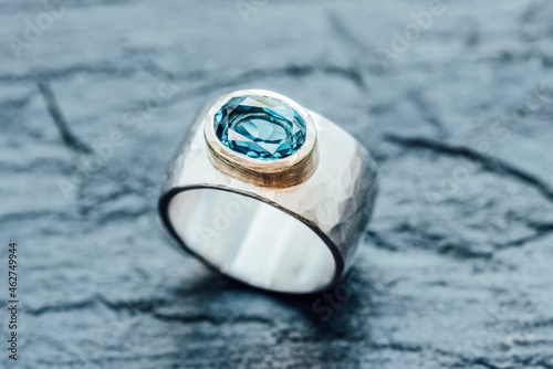 Silver ring with Topaz in gold setting on slate photo
