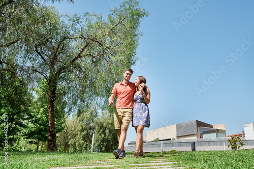 Happy young couple walking trough a park