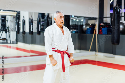 Senior man practicing karate in gym photo
