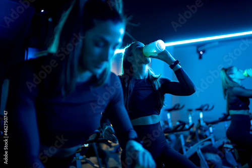 Woman on spinning bike in gym having a cooling break photo