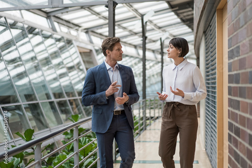 Businessman and woman talking in sustainable office building photo