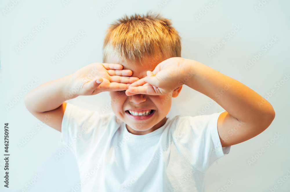 Boy covering his eyes in front of white background Stock Photo | Adobe ...