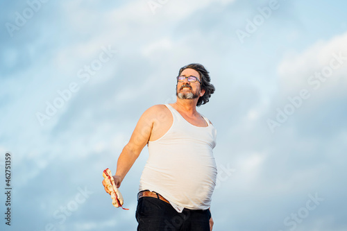 Man with beer belly holding sandwich