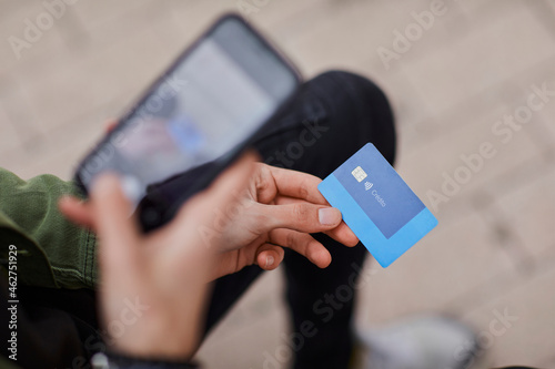 Man taking photo of credit card through mobile phone