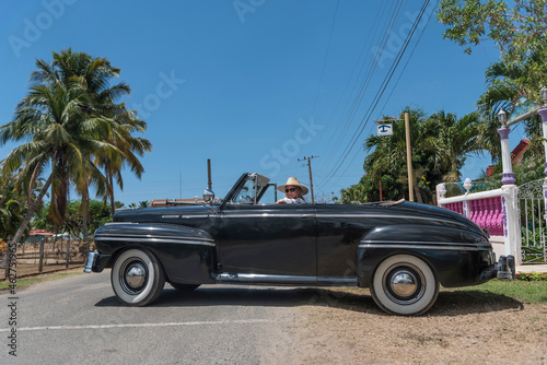 Woman in a vintage convertible car on Cuba