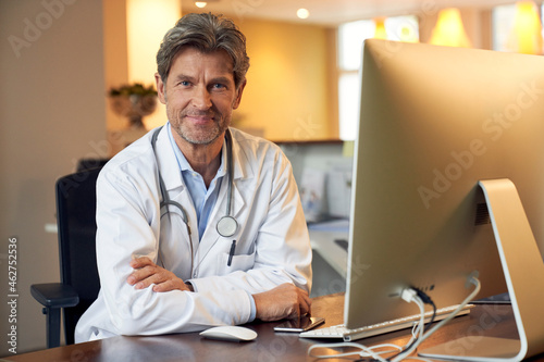 Portrait of confident doctor at desk in his medical practice
