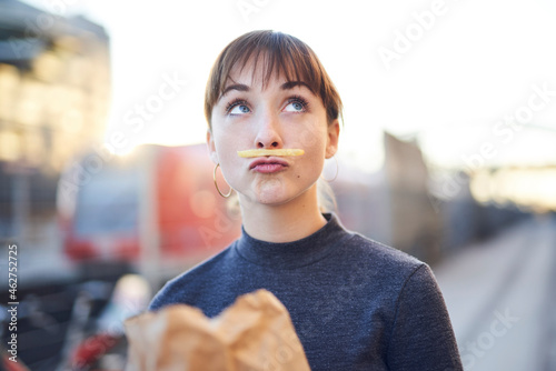 Portrait of young woman with French Fries moustache pouting mouth