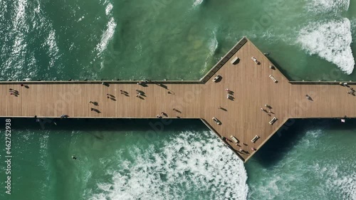 Perfect waves running on sandy beach with copy and text space on green blue ocean. Tourists enjoying summer beach vacation 4K. Cinematic top down view on scenic pier at Pismo Beach, California USA photo