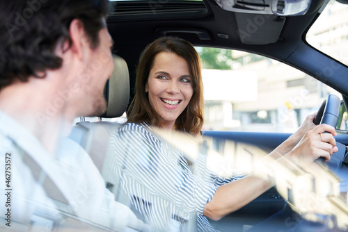 Happy couple in a car with woman driving photo